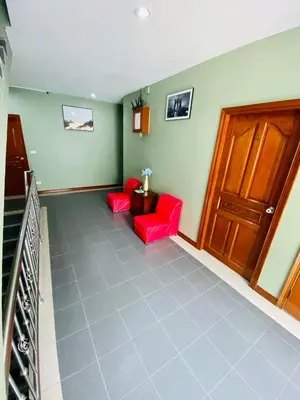 a living room with two red chairs and a door at BT hotel Kata Beach in Kata Beach