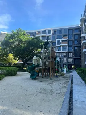 a playground in a park in front of a building at Modern 2-bedroom Apartments with washer in Skypark Laguna Bang Tao in Phuket Town