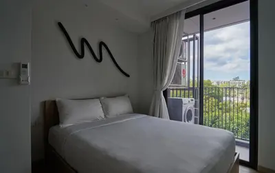 a bedroom with a bed and a large window at Modern 2-bedroom Apartments with washer in Skypark Laguna Bang Tao in Phuket Town