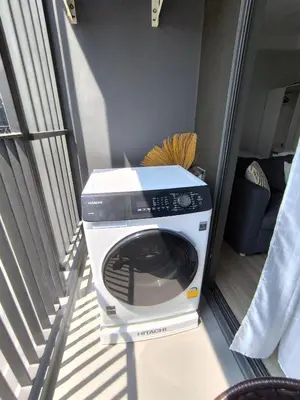 a washer and dryer sitting in a room at Cozy 1-bedroom Apartments in Laguna Skypark Bang Tao in Phuket Town