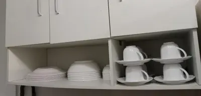a shelf with white dishes and plates on it at STP apartment 2rd floor in Patong Beach