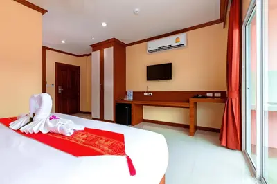a hotel room with a bed and a television at Phusita Hotel - SHA Certified in Patong Beach