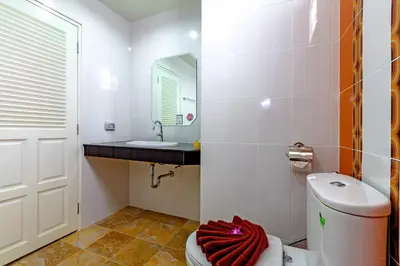 a bathroom with a toilet and a sink and a mirror at Phusita Hotel - SHA Certified in Patong Beach