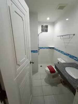 a white bathroom with a toilet and a sink at Phusita Hotel - SHA Certified in Patong Beach