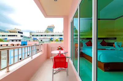 a balcony with a bed and a table at Phusita Hotel - SHA Certified in Patong Beach