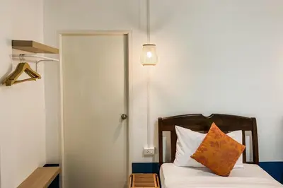 a bedroom with a bed with a pillow and a lamp at House No.2 Village in Krabi town