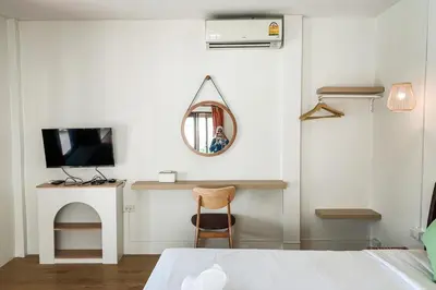 a bedroom with a bed and a mirror and a desk at House No.2 Village in Krabi town