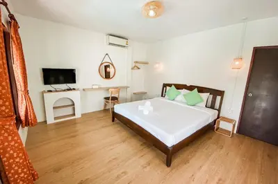 a bedroom with a large bed and a television at House No.2 Village in Krabi town