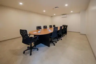 a conference room with a wooden table and black chairs at Niranapa Boutique Resort in Kata Beach