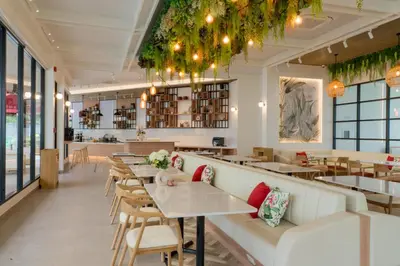 a restaurant with couches and tables and chairs at Niranapa Boutique Resort in Kata Beach