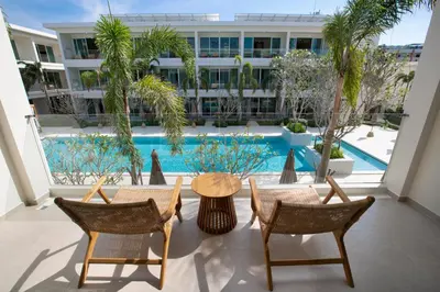 a patio with a table and chairs and a pool at Niranapa Boutique Resort in Kata Beach