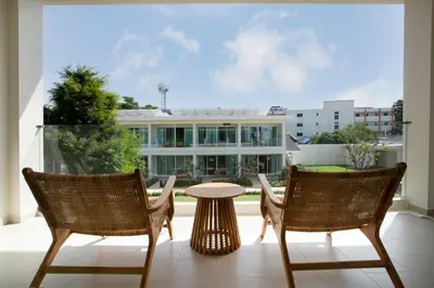 two chairs and a table on a balcony with a building at Niranapa Boutique Resort in Kata Beach
