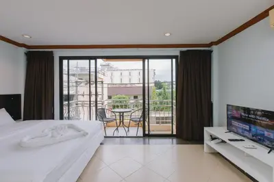 a bedroom with a bed and a tv and a balcony at Sunstar Palace Patong in Patong Beach