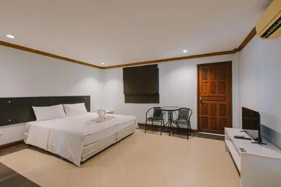 a bedroom with a bed and a table and chairs at Sunstar Palace Patong in Patong Beach