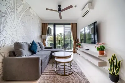 a living room with a couch and a table at Cassia 2 BR Sea View apt by NLA in Phuket Town
