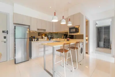 a kitchen with a island with bar stools at Cassia 2 BR Sea View apt by NLA in Phuket Town