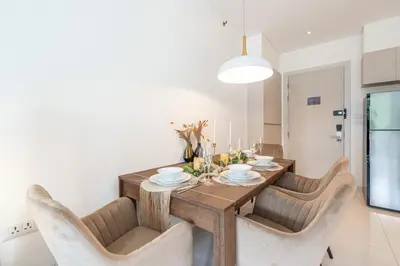 a dining room with a wooden table and chairs at Cassia 2 BR Sea View apt by NLA in Phuket Town