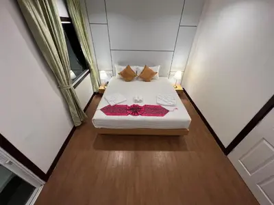 a small bedroom with a white bed with a bow on it at Zephyr Grand Hotel in Patong Beach