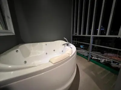 a white bath tub in a room with a window at Zephyr Grand Hotel in Patong Beach