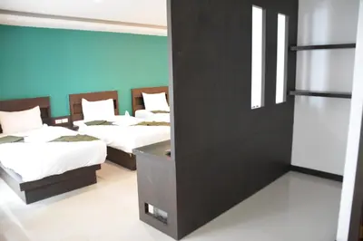 a room with three beds and a mirror at Zephyr Grand Hotel in Patong Beach