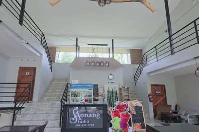 a room with stairs and a shelf with books at Aonangstudio in Krabi town