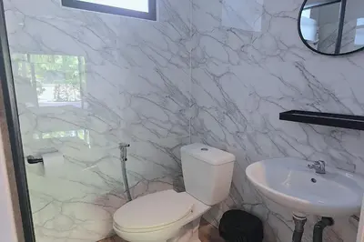 a white bathroom with a toilet and a sink at Aonangstudio in Krabi town