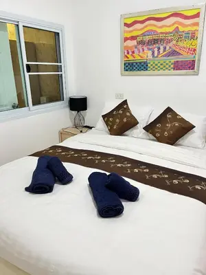 a bedroom with two beds with blue pillows on them at Elephant Sports Bar and Accommodation in Phuket Town