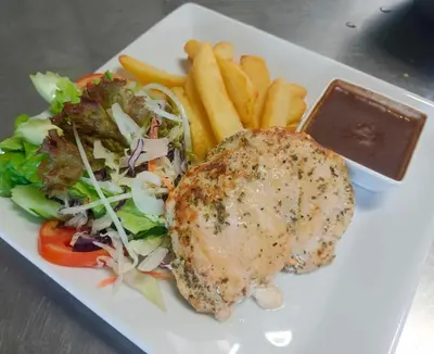 a plate of food with a chicken and salad and french fries at Elephant Sports Bar and Accommodation in Phuket Town