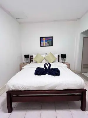 a bedroom with a bed with a blue bow on it at Elephant Sports Bar and Accommodation in Phuket Town