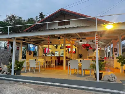 a restaurant with white tables and chairs and a table and chairs at Elephant Sports Bar and Accommodation in Phuket Town