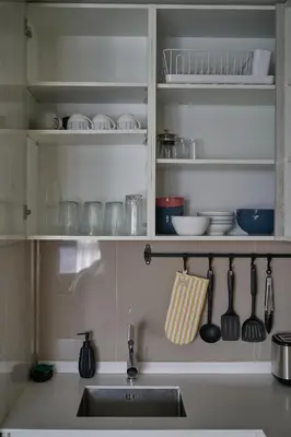 a kitchen with a sink and a shelf with dishes at Modern 2-bedroom Apartments Garden view in Skypark Laguna Bang Tao in Bang Tao Beach