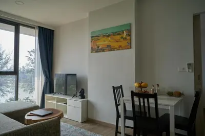 a living room with a couch and a table and a desk at Modern 2-bedroom Apartments Garden view in Skypark Laguna Bang Tao in Bang Tao Beach
