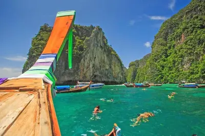 a group of people swimming in the water on a boat at The Cobble Beach Hotel- Phi Phi Island in Phi Phi Don