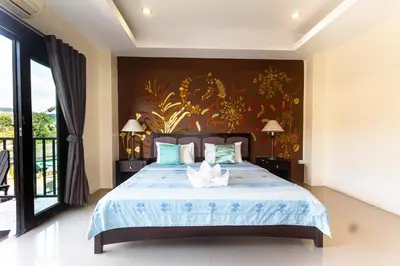 a bedroom with a large bed with a painting on the wall at KRABI MORE HOTEL in Klong Muang Beach