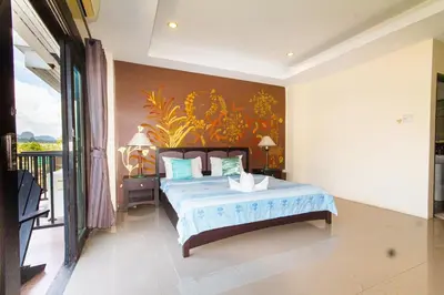 a bedroom with a bed with a blue comforter at KRABI MORE HOTEL in Klong Muang Beach