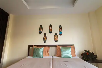 a bedroom with a bed with masks on the wall at KRABI MORE HOTEL in Klong Muang Beach