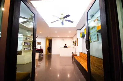a room with a ceiling fan and a person sitting at a counter at KRABI MORE HOTEL in Klong Muang Beach