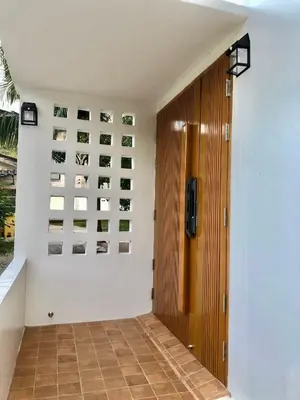 a hallway with a wooden door and pictures on the wall at Cozy Private Pool Villa For Family - Halal in Ban Thalat Choeng Thale
