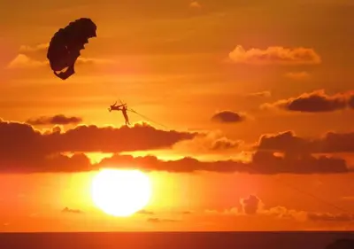 a kite flying in front of a sunset at The Blue Bay Experience in Kata Beach