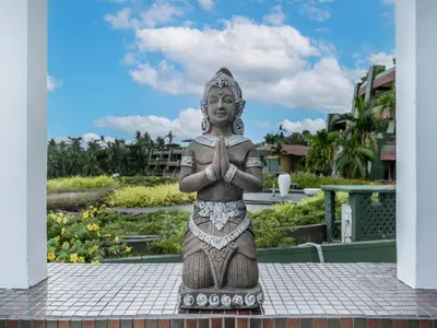 a statue of a woman sitting on top of a building at The Blue Bay Experience in Kata Beach