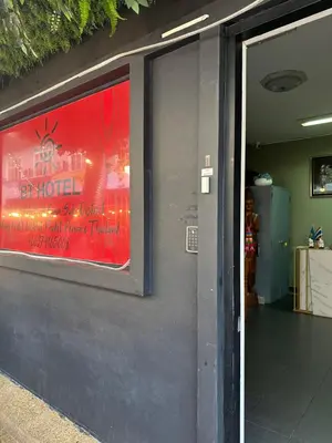 a glass door of a building with a red sign at BT hotel Kata Beach in Kata Beach