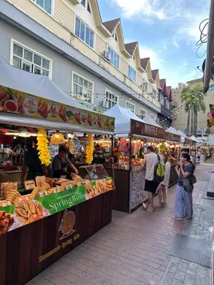 a group of people standing around a market with food at BT hotel Kata Beach in Kata Beach