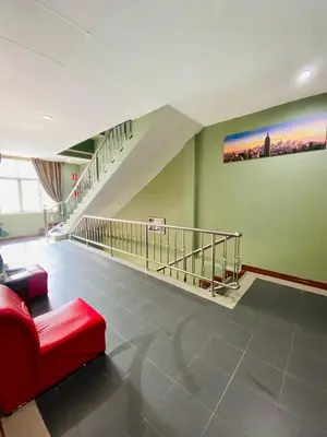 a living room with a red couch and a staircase at BT hotel Kata Beach in Kata Beach