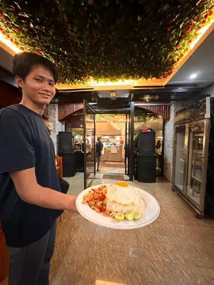 a man holding a plate with a plate of food at BT hotel Kata Beach in Kata Beach