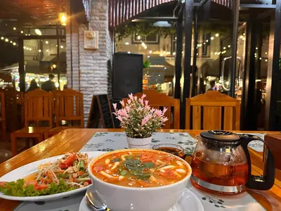 a bowl of soup and a plate of food on a table at BT hotel Kata Beach in Kata Beach