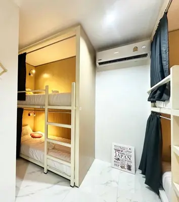 a bedroom with two bunk beds and a mirror at Airhub Hostel Phuket Airport in Nai Yang Beach