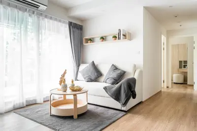 a living room with a white couch and a table at Phyll Phuket 2 BR apartment near Central Festival by NLA in Phuket Town