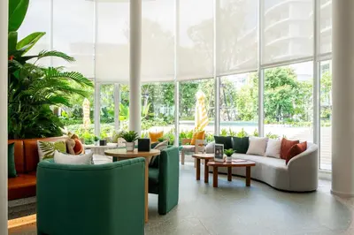 a living room with green furniture and large windows at Phyll Phuket 2 BR apartment near Central Festival by NLA in Phuket Town