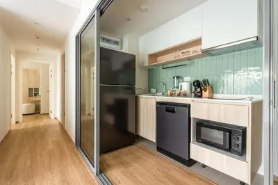 a kitchen with a stainless steel refrigerator and a stove at Phyll Phuket 2 BR apartment near Central Festival by NLA in Phuket Town