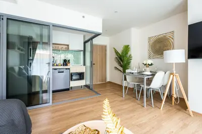 a living room with a table and a kitchen at Phyll Phuket 2 BR apartment near Central Festival by NLA in Phuket Town